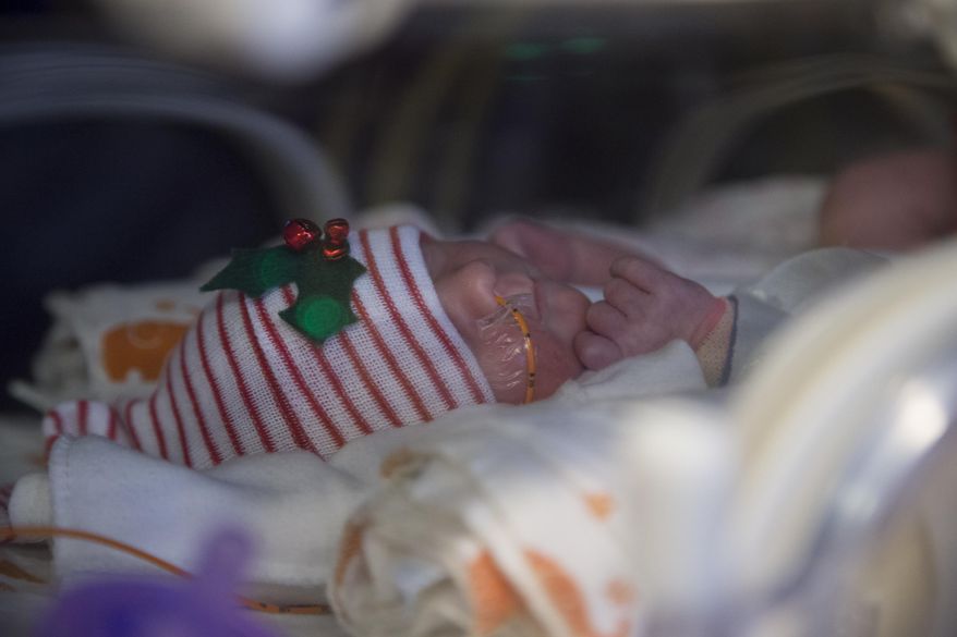 Ava Baudinet, one of a set of quintuplets recently born, rests at the St. Joseph's Nursery Intensive Care Unit, Wednesday, Dec, 21, 2016, in Phoenix. Margaret Baudinet gave birth on Dec. 4 to five healthy babies. (Mark Henle/The Arizona Republic via AP)
