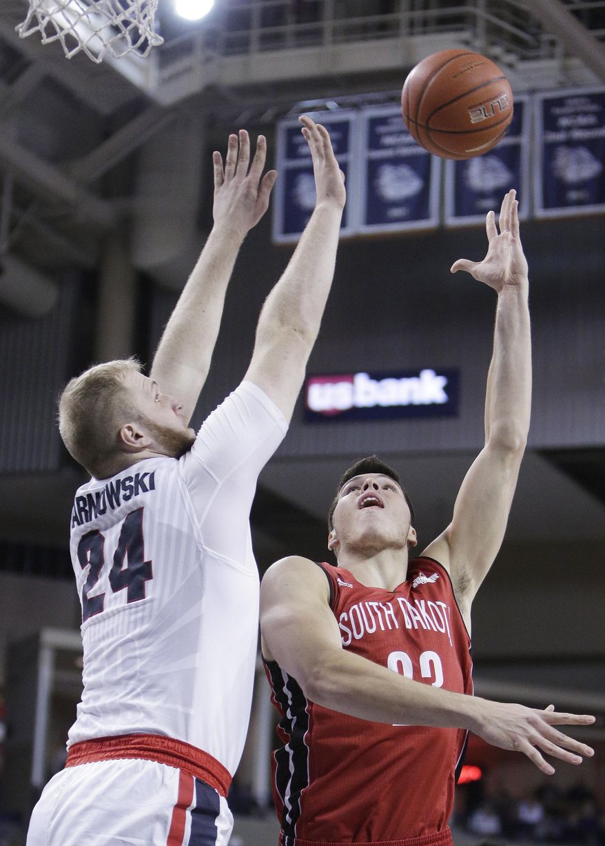 South Dakota forward Tyler Flack, right, shoots while defended by Gonzaga center Przemek Karnowski (24) during the first half of an NCAA college basketball game in Spokane, Wash., Wednesday, Dec. 21, 2016. (AP Photo/Young Kwak)