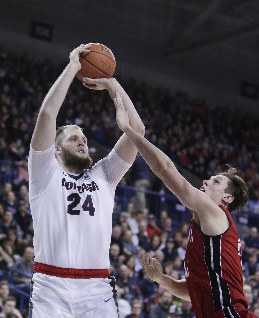 Gonzaga center Przemek Karnowski (24) shoots while defended by South Dakota forward Austin Sparks during the first half of an NCAA college basketball game in Spokane, Wash., Wednesday, Dec. 21, 2016. (AP Photo/Young Kwak)