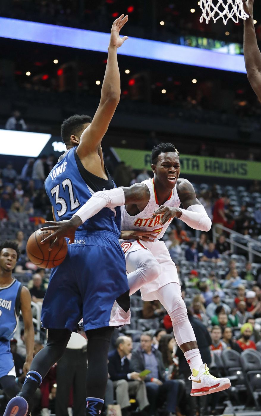 Atlanta Hawks guard Dennis Schroder (17) passes as he drives against Minnesota Timberwolves center Karl-Anthony Towns (32) in the first half of an NBA basketball game Wednesday, Dec. 21, 2016, in Atlanta. (AP Photo/John Bazemore)
