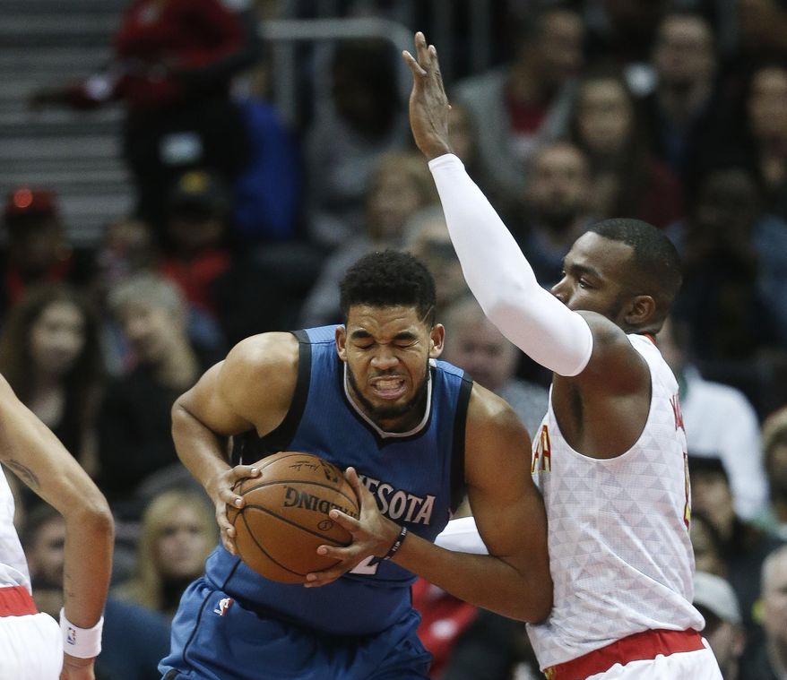 Minnesota Timberwolves center Karl-Anthony Towns (32) works against Atlanta Hawks forward Paul Millsap (4) in the first half of an NBA basketball game Wednesday, Dec. 21, 2016, in Atlanta. (AP Photo/John Bazemore)
