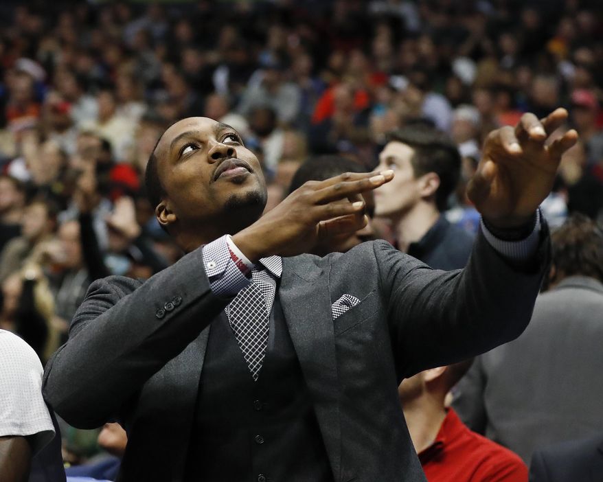 Injured Atlanta Hawks center Dwight Howard (8) gestures after a Hawks three-point basket in the second half of an NBA basketball game against the Minnesota Timberwolves Wednesday, Dec. 21, 2016, in Atlanta. Minnesota won 92-84. (AP Photo/John Bazemore)