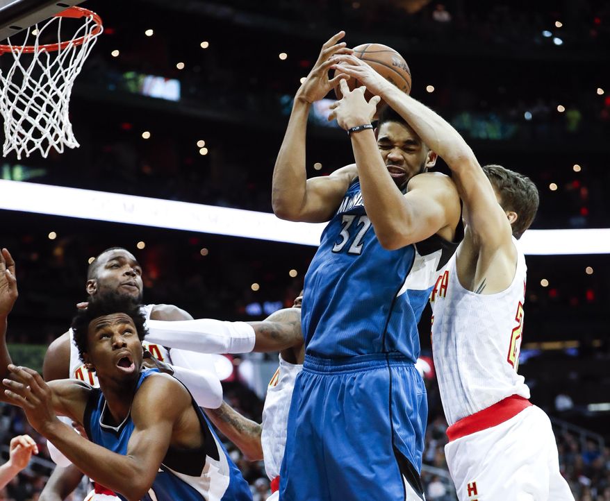 Minnesota Timberwolves center Karl-Anthony Towns (32) and Atlanta Hawks guard Kyle Korver (26) battle for a rebound as Minnesota forward Andrew Wiggins (22) looks on at left in the second half of an NBA basketball game Wednesday, Dec. 21, 2016, in Atlanta. Minnesota won 92-84. (AP Photo/John Bazemore)