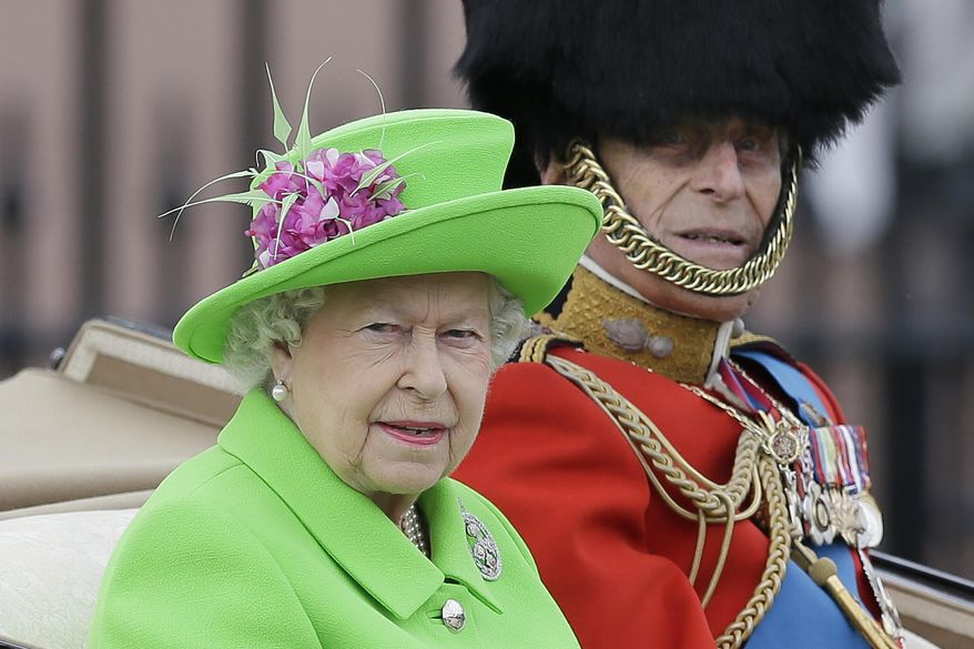 FILE - In this Saturday, June 11, 2016 file photo, Britain's Queen Elizabeth and Prince Philip ride in a carriage during the Trooping The Colour parade at Buckingham Palace, in London. Buckingham Palace officials say Queen Elizabeth II and her husband Prince Philip have delayed their planned Christmas trip because both are suffering from heavy colds. The palace said the pair had been planning to travel by train to the queen's country estate Wednesday, Dec. 21, 2016 but have postponed the trip. (AP Photo/Tim Ireland, file)