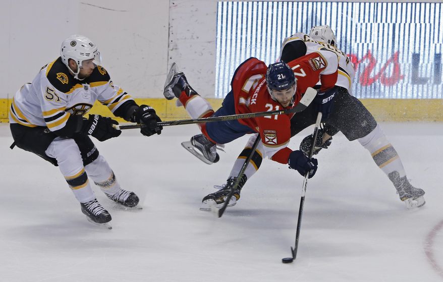 Florida Panthers center Vincent Trocheck (21) is upended by Boston Bruins defenseman Colin Miller (6) as Boston Bruins center Ryan Spooner (51) approaches in the second period of an NHL hockey game, Thursday, Dec. 22, 2016, in Sunrise, Fla. (AP Photo/Joe Skipper)