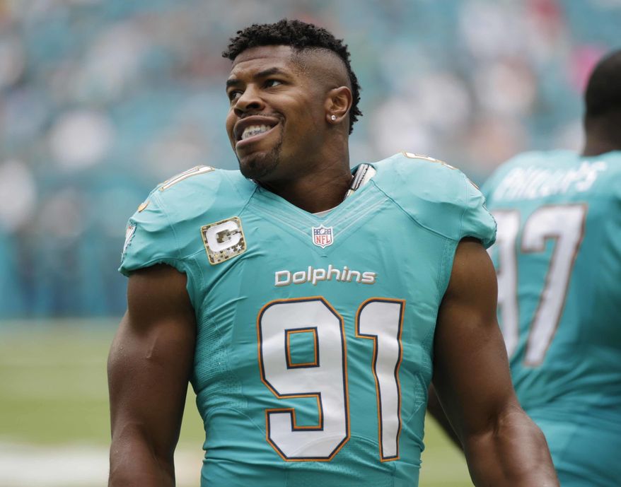 This Nov. 6, 2016 photo shows Miami Dolphins defensive end Cameron Wake (91) standing on the sidelines during the first half of an NFL football game against the New York Jets in Miami Gardens, Fla. Wake is a Pro Bowl defensive end for the fifth time, capping his comeback from a torn Achilles tendon. And now he has a chance to play in the postseason for the first time. (AP Photo/Wilfredo Lee)