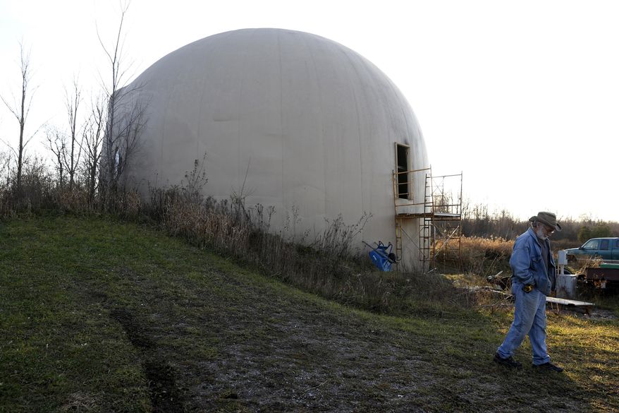 In this Nov. 29, 2016 photo, Wayne Price, 60, walks outside the the 4,650 square feet concrete monolithic dome he was in the processes of building in Otisville, Mich. Financial realities have forced Price to abandon his dream of finishing, and living in, a dome home. Price is selling the unfinished monolithic domed structure for $150,000 after he estimates sinking roughly $200,000 in the project over 16 years (Tegan Johnston/The Flint Journal-MLive.com via AP)