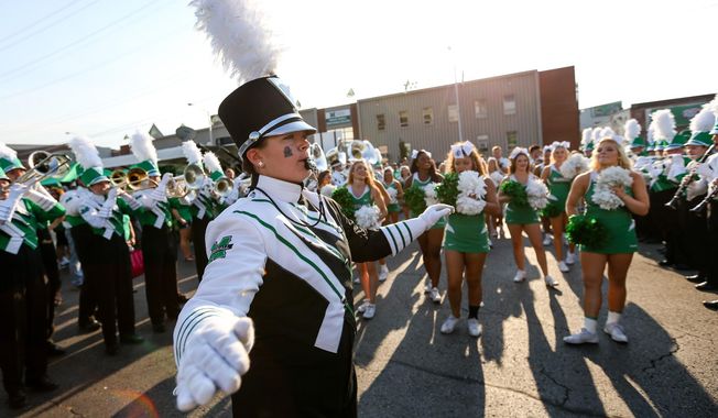ADVANCE FOR WEEKEND EDITIONS - In this Saturday, Oct. 22, 2016, photo, Marshall University Marching Thunder Drum Major Mary Bunten leads the band in a performance as Marshall fans tailgate prior to the start of the Thundering Herd&#x27;s football game against Louisville at Joan C. Edwards Stadium in Huntington, W.Va. The Marching Thunder will perform in the Rome New Year&#x27;s Day Parade in Rome, Italy, on Jan. 1, 2017. (Sholten Singer/The Register-Herald via AP)