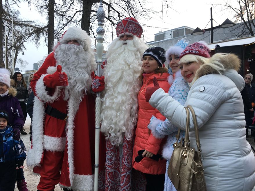 Finland's Santa, left, and Russia's Grandfather Frost, 2nd left, meet families in the border town of Lappeenranta, Finland on Monday Dec. 19, 2016, as an annual show of goodwill and neighborly friendship. But despite the jovial ho-ho-hos in the annual show of seasonal goodwill and neighborly friendship, there lies an increasing disquiet in the Nordic nation. (AP Photo/Vitnija Saldava)