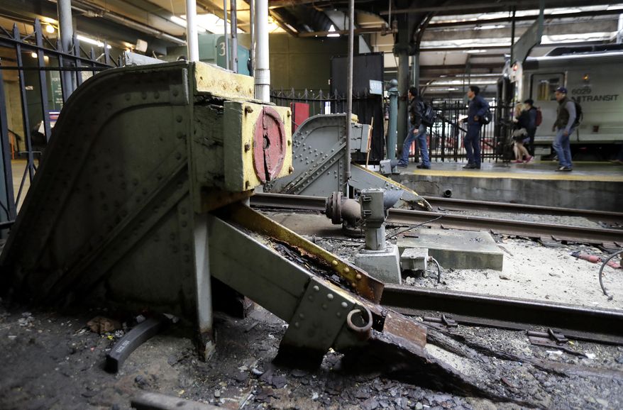 In a photograph taken Wednesday, Nov. 30, 2016, bumping posts sit seen as people get of a New Jersey Transit train near at the Hoboken Train Terminal in Hoboken, N.J. Only one of the terminal's tracks features a modern bumping post. The post on Track 15 is the only post featuring a modern post designated to stop a runaway train. The other posts were installed more than 100 years ago and recently became relevant in the wake of the New Jersey Transit train crash that occurred Sept. 29, 2016. (AP Photo/Julio Cortez)