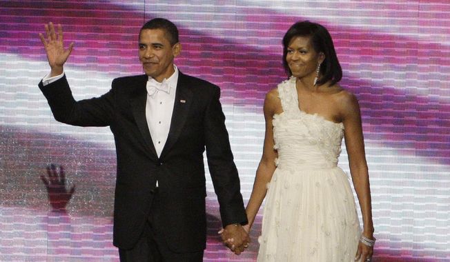 This Jan. 20, 2009, file photo shows President Barack Obama, left, and first lady Michelle Obama, in a one-shouldered white gown by designer Jason Wu, at the Neighborhood Inaugural Ball in Washington. (AP Photo/Alex Brandon, File)