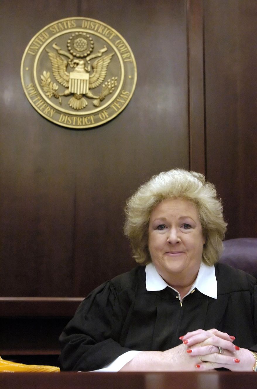 In this Dec. 22, 2005 photo, U.S. District Judge Janis Graham Jack, who was appointed by President Bill Clinton in 1994 to fill a new judicial post in the Southern District of Texas, poses in a courtroom of the Southern District of Texas, in Texas. The federal judge who ruled that Texas' foster care system is unconstitutionally broken has been named The Dallas Morning News' Texan of the Year. The newspaper announced Friday, Dec. 23, 2016, that Jack was being recognized because she "punctured our comfortable obliviousness to the appalling treatment" being endured by the 12,000 children labeled permanent wards of the state. (Rachel Denny Clow /Corpus Christi Caller-Times via AP)