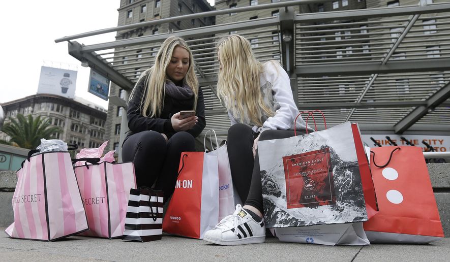 FILE - In this Nov. 25, 2016, file photo, Maddy, left, and her friend Maggie, sit with their shopping bags at Union Square in San Francisco. The holiday shopping season is losing some of its power in the year's sales. November and December now account for less than 21 percent of annual retail sales at physical stores, down from a peak of over 25 percent. The shift is in part because people are spreading out their shopping all year, demanding big discounts and spending more on events rather than more stuff. (AP Photo/Jeff Chiu, File)