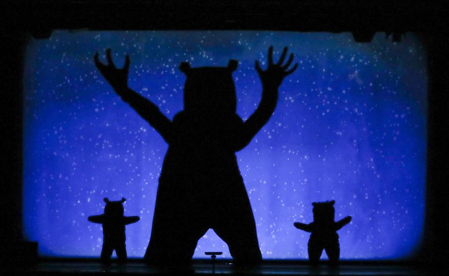 In this photo taken on Tuesday, Dec. 20, 2016, dancers of the U.S. company 'Catapult' create bears under a snowfall, during their show 'Magic Shadows', in Milan, Italy. Dancers in the company create shadow sculptures with their bodies, giving a contemporary twist to the ancient Chinese art of shadow theaters. (AP Photo/Luca Bruno)