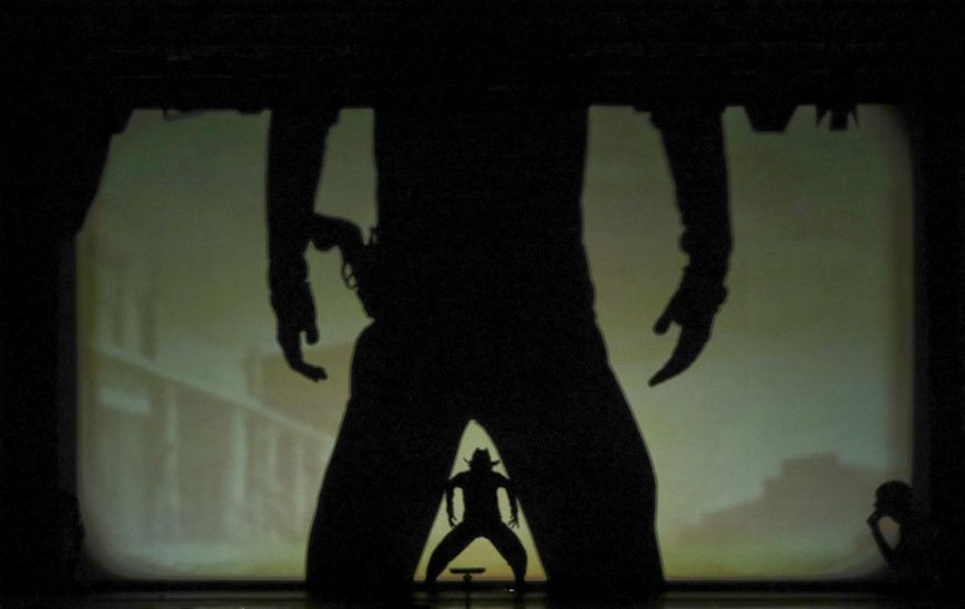 In this photo taken on Tuesday, Dec. 20, 2016, dancers of the U.S. company 'Catapult' create a Western duel, during their show 'Magic Shadows', in Milan, Italy. Dancers in the company create shadow sculptures with their bodies, giving a contemporary twist to the ancient Chinese art of shadow theaters. (AP Photo/Luca Bruno)