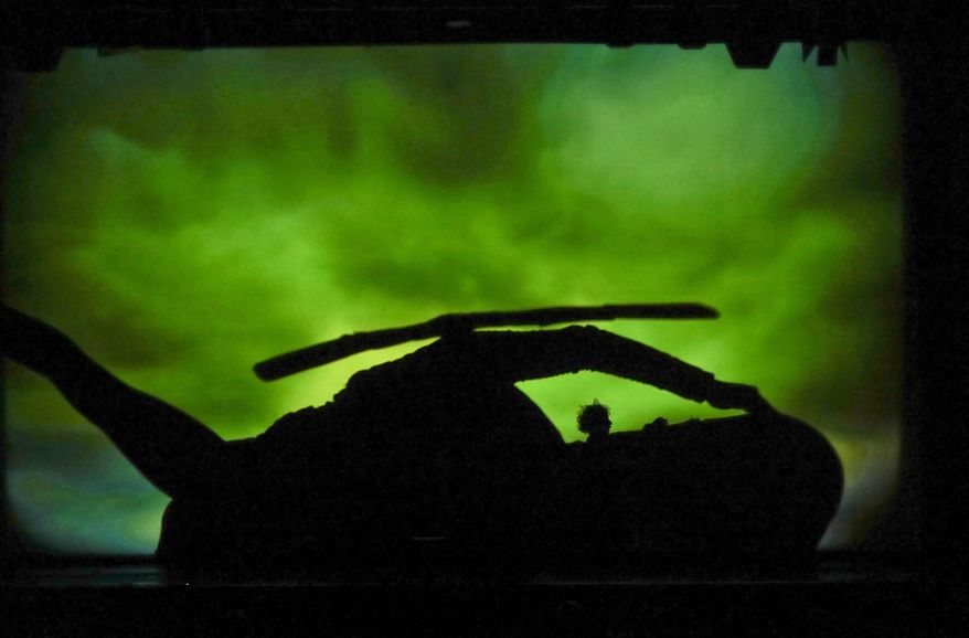 In this photo taken on Tuesday, Dec. 20, 2016, dancers of the U.S. company 'Catapult' create an helicopter, during their show 'Magic Shadows', in Milan, Italy. Dancers in the company create shadow sculptures with their bodies, giving a contemporary twist to the ancient Chinese art of shadow theaters. (AP Photo/Luca Bruno)