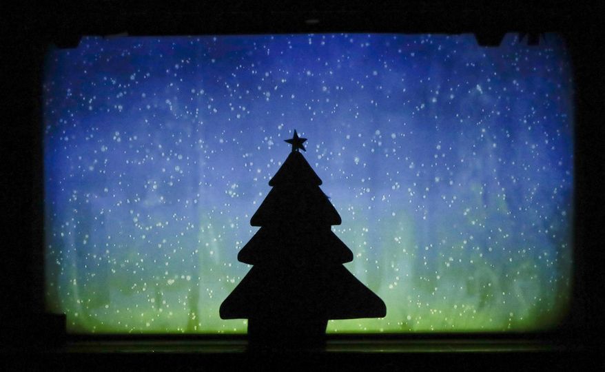 In this photo taken on Tuesday, Dec. 20, 2016, dancers of the U.S. company 'Catapult' create a Christmas tree, during their show 'Magic Shadows', in Milan, Italy. Dancers in the company create shadow sculptures with their bodies, giving a contemporary twist to the ancient Chinese art of shadow theaters. (AP Photo/Luca Bruno)