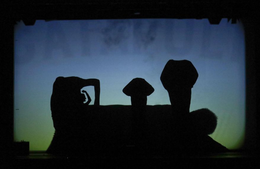 In this photo taken on Tuesday, Dec. 20, 2016, dancers of the U.S. company 'Catapult' create a train, during their show 'Magic Shadows', in Milan, Italy. Dancers in the company create shadow sculptures with their bodies, giving a contemporary twist to the ancient Chinese art of shadow theaters. (AP Photo/Luca Bruno)