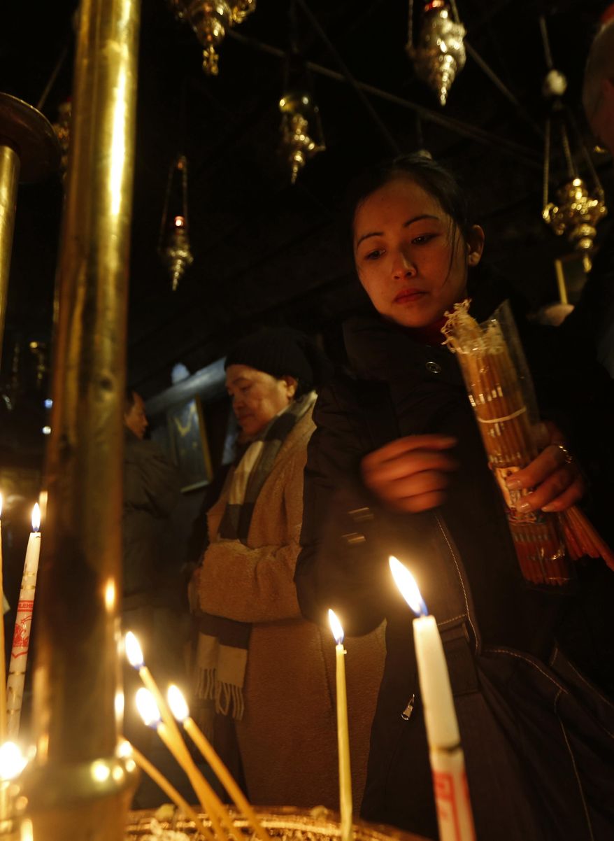 Christian worshippers light candles in the Church of the Nativity, built atop the site where Christians believe Jesus Christ was born, on Christmas Eve, in the West Bank City of Bethlehem, Saturday, Dec. 24, 2016. (AP Photo/Majdi Mohammed)