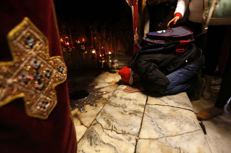 A Christian worshiper kisses the ground near the silver star which marks the place where it is believed Jesus Christ was born, in the Grotto at the Church of the Nativity, in the West Bank City of Bethlehem, Saturday, Dec. 24, 2016. (AP Photo/Majdi Mohammed)