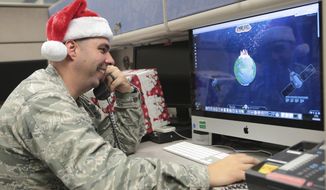 Maj. Jared Scott, makes sure NORAD&#39;s Santa tracker is working correctly at Tyndall Air Force Base on Friday, Dec. 23, 2016 in Panama City, Fla. (Heather Howard/News Herald via AP)