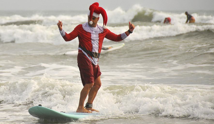 Cocoa Beach City commissioner Ed Martinez participates in the Surfing Santas event in Cocoa Beach, Fla., Saturday, Dec. 24, 2016. The Christmas event supports Grind for Life and the Surf Museum. (Malcolm Denemark/Florida Today via AP)