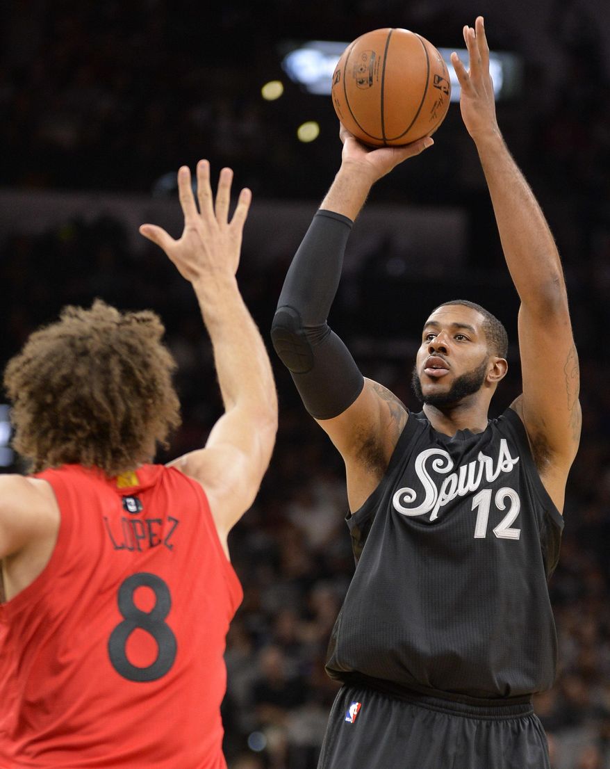 San Antonio Spurs forward LaMarcus Aldridge (12) shoots against Chicago Bulls center Robin Lopez during the first half of an NBA basketball game, Sunday, Dec. 25, 2016, in San Antonio. (AP Photo/Darren Abate)
