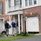 Law enforcement officers work outside the home of Nicholas Young on Aug. 3, 2016, in Fairfax, Virginia. Young, who worked as a Metro police officer, has been charged with helping the Islamic State. (Associated Press)