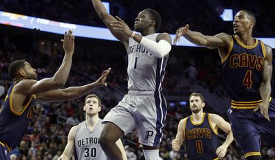 Detroit Pistons guard Reggie Jackson (1) goes to the basket while defended by Cleveland Cavaliers center Tristan Thompson, left, and guard Iman Shumpert (4) during the first half of an NBA basketball game, Monday, Dec. 26, 2016, in Auburn Hills, Mich. (AP Photo/Duane Burleson)