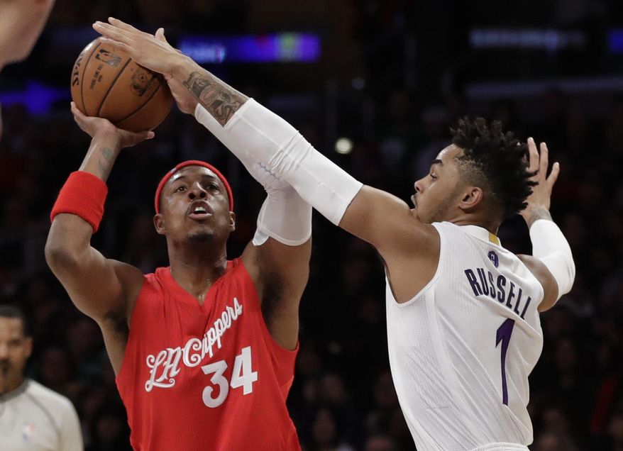 Los Angeles Clippers forward Paul Pierce, left, shoots over Los Angeles Lakers guard D'Angelo Russell during the first half of an NBA basketball game in Los Angeles, Sunday, Dec. 25, 2016. (AP Photo/Chris Carlson)