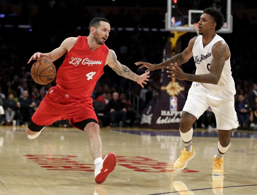 Los Angeles Clippers guard J.J. Redick, left, drives to the basket past Los Angeles Lakers guard Nick Young during the first half of an NBA basketball game in Los Angeles, Sunday, Dec. 25, 2016. (AP Photo/Chris Carlson)