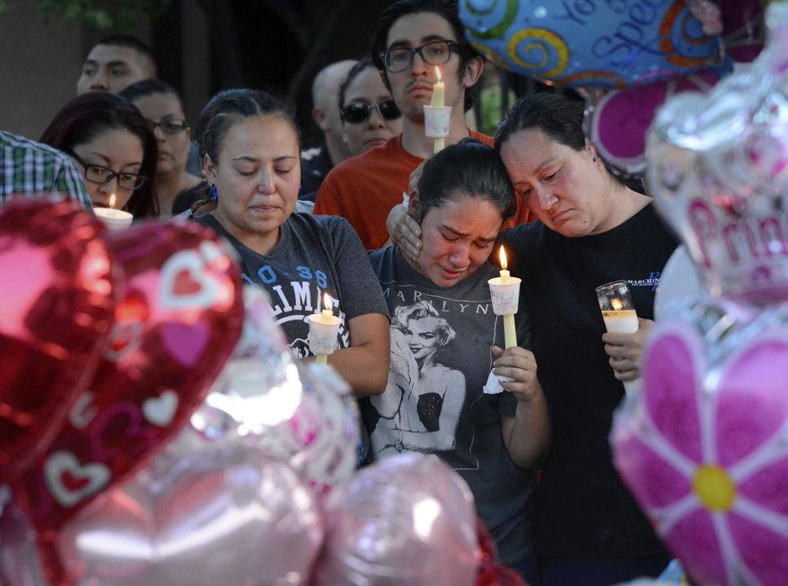 FILE - In this Thursday Aug. 25, 2016, file photo, from left to right, Nicole Maldonado, Myriah Flores and her mother Sharlene Benavidez attend a candlelight vigil for Victoria Martens at the apartment complex, in Albuquerque, N.M., where the young girl lived and was killed. The brutality of Victoria’s slaying sent shockwaves through New Mexico in August, but it marked only one of a handful of heartbreaking cases involving children in 2016. (Jim Thompson/The Albuquerque Journal via AP, File)