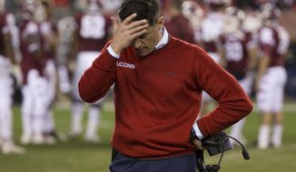 FILE - In this Nov. 28, 2015, file photo, Connecticut head coach Bob Diaco looks down as he rubs his head during the second half of an NCAA college football game against the Temple in Philadelphia. UConn athletic director David Benedict announced Monday, Dec. 26, 2016, that head football coach Bob Diaco has been relieved of his coaching duties, effective Jan. 2.  (AP Photo/Chris Szagola, File)