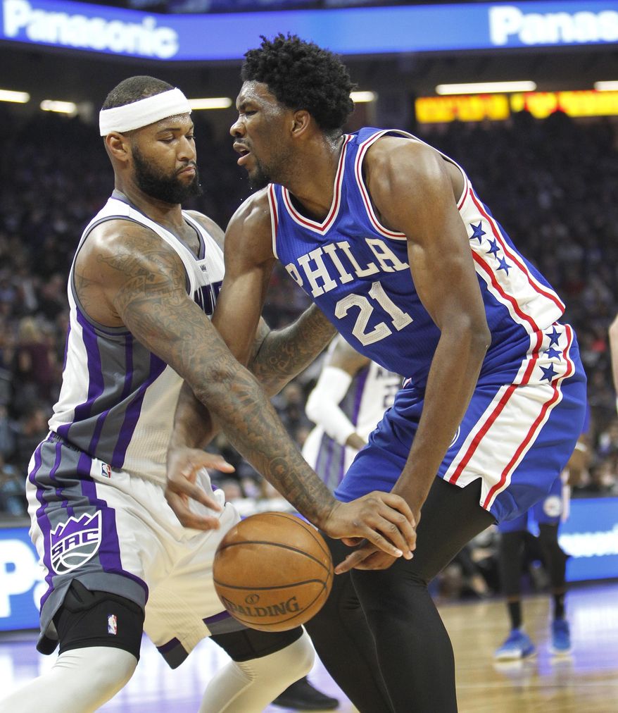 Philadelphia 76ers center Joel Embiid (21) battles for a loose ball with Sacramento Kings center DeMarcus Cousins (15) during the first half of an NBA basketball game in Sacramento, Calif., Monday, Dec. 26, 2016. (AP Photo/Steve Yeater)