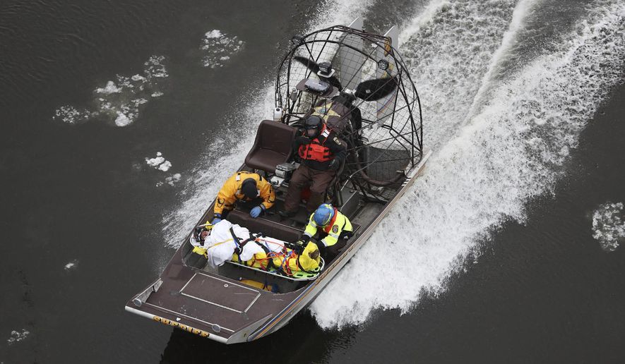 Rescue personnel transfer an accident victim by airboat down the Mississippi River, seen from the Franklin Avenue Bridge, Tuesday, Dec. 27, 2016, in Minneapolis. Minneapolis fire department rescued a motorist after a car plunged down the Mississippi River bank. (David Joles/Star Tribune via AP)