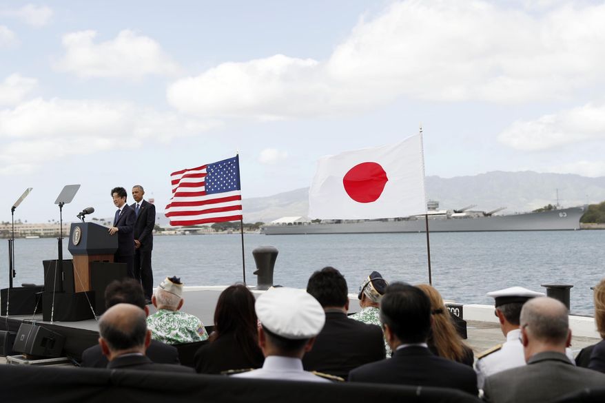 U.S. President Barack Obama listens as Japanese Prime Minister Shinzo Abe speaks on Kilo Pier overlooking the USS Arizona Memorial, part of the World War II Valor in the Pacific National Monument, in Joint Base Pearl Harbor-Hickam, Hawaii, adjacent to Honolulu, Hawaii, Tuesday, Dec. 27, 2016, as part of a ceremony to honor those killed in the Japanese attack on the naval harbor. (AP Photo/Carolyn Kaster)