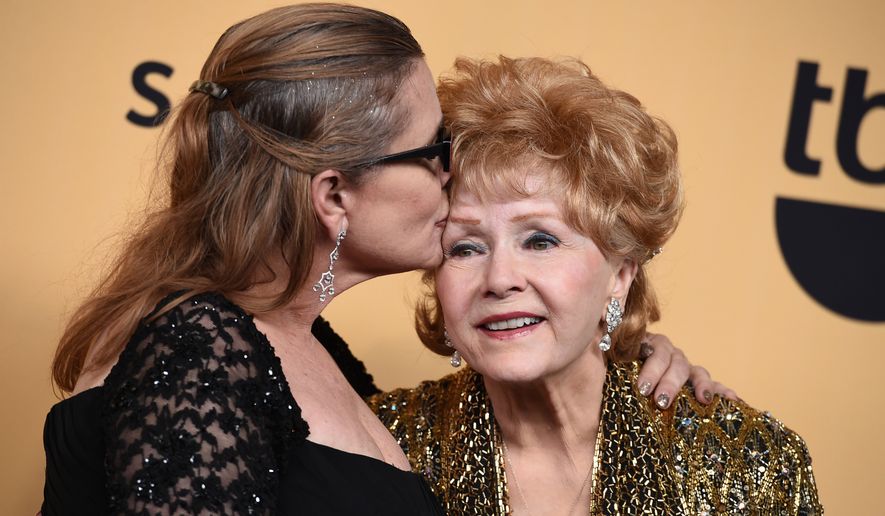 Carrie Fisher and her mother Debbie Reynolds — winner of the Screen Actors Guild lifetime award — pose in the press room at the 21st annual Screen Actors Guild Awards on Jan. 25, 2015, at the Shrine Auditorium in Los Angeles. (Associated Press)
