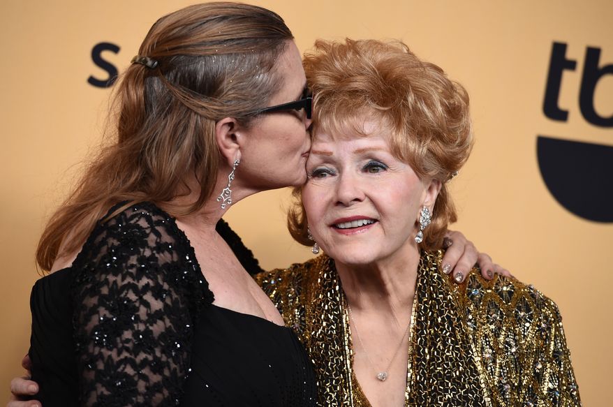 Carrie Fisher and her mother Debbie Reynolds — winner of the Screen Actors Guild lifetime award — pose in the press room at the 21st annual Screen Actors Guild Awards on Jan. 25, 2015, at the Shrine Auditorium in Los Angeles. (Associated Press)
