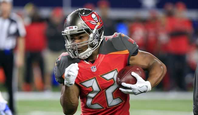 This Dec. 18, 2016 photo shows Tampa Bay Buccaneers' Doug Martin (22) carrying the ball in the first half of an NFL football game against the Dallas Cowboys in Arlington, Texas. Martin has been suspended four games for violating the NFL's policy on performance enhancing substances and said Wednesday, Dec. 28, 2016 he's entering a treatment facility rather than appeal the ban. (AP Photo/Ron Jenkins)