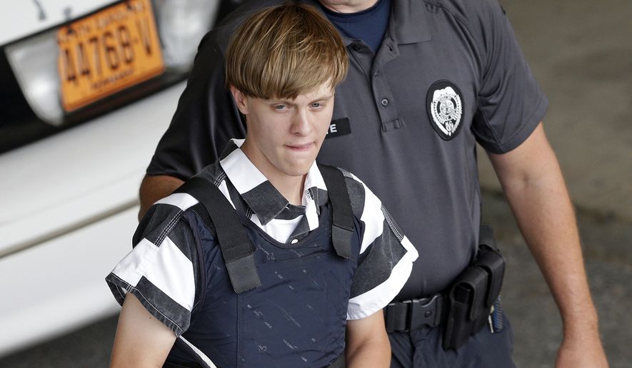 In this June 18, 2015, file photo, Charleston, S.C., shooting suspect Dylann Storm Roof is escorted from the Cleveland County Courthouse in Shelby, N.C. 2015 was supposed to be the uneasy year in South Carolina. The state was stunned by a videotaped police shooting of a fleeing black motorist, nine churchgoers killed in a hate crime, and a billion-dollar flood. (AP Photo/Chuck Burton, File)