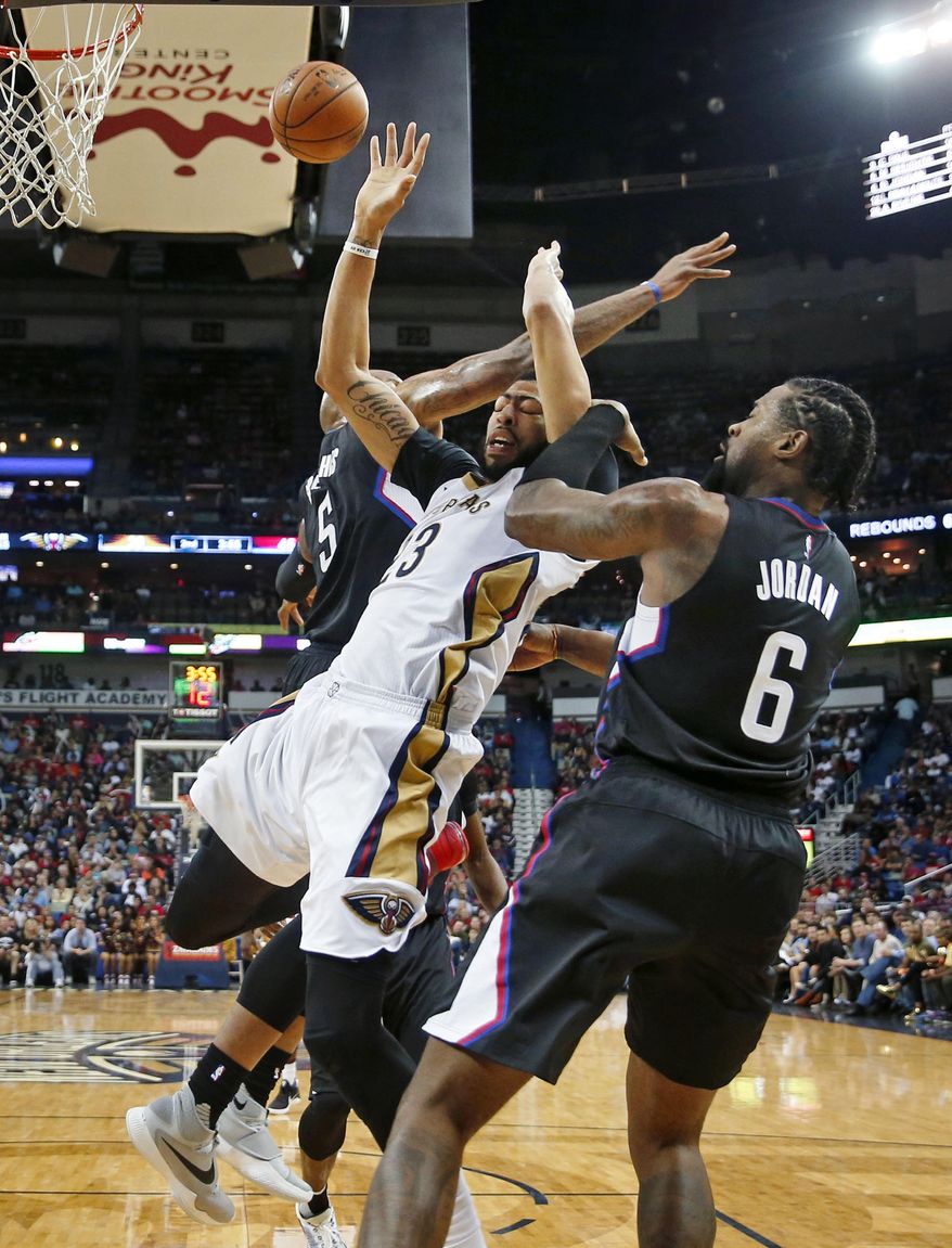 New Orleans Pelicans forward Anthony Davis (23) is stopped as he goes to the basket between Los Angeles Clippers' DeAndre Jordan (6) and Marreese Speights (5) during the first half of an NBA basketball game in New Orleans, Wednesday, Dec. 28, 2016. (AP Photo/Gerald Herbert)