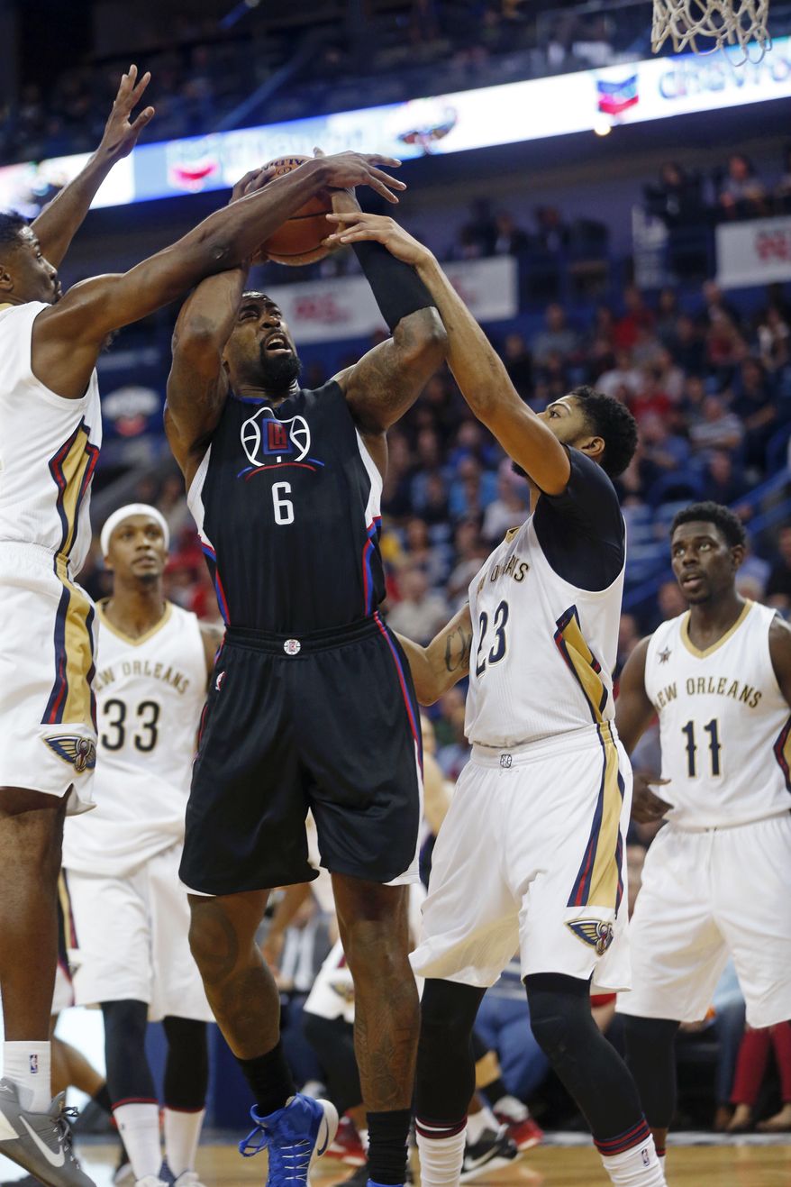 Los Angeles Clippers center DeAndre Jordan (6) is fouled by New Orleans Pelicans forward Anthony Davis (23) as he goes to the basket against Davis and forward Solomon Hill, left, during the first half of an NBA basketball game in New Orleans, Wednesday, Dec. 28, 2016. (AP Photo/Gerald Herbert)