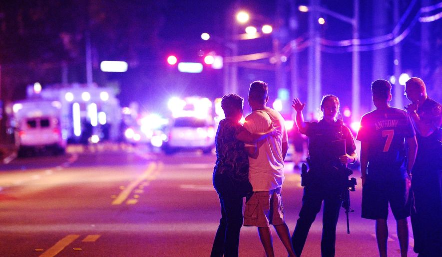 In this June 12, 2016, file photo, Orlando Police officers direct family members away from a fatal shooting at Pulse nightclub in Orlando, Fla. (AP Photo/Phelan M. Ebenhack, File)