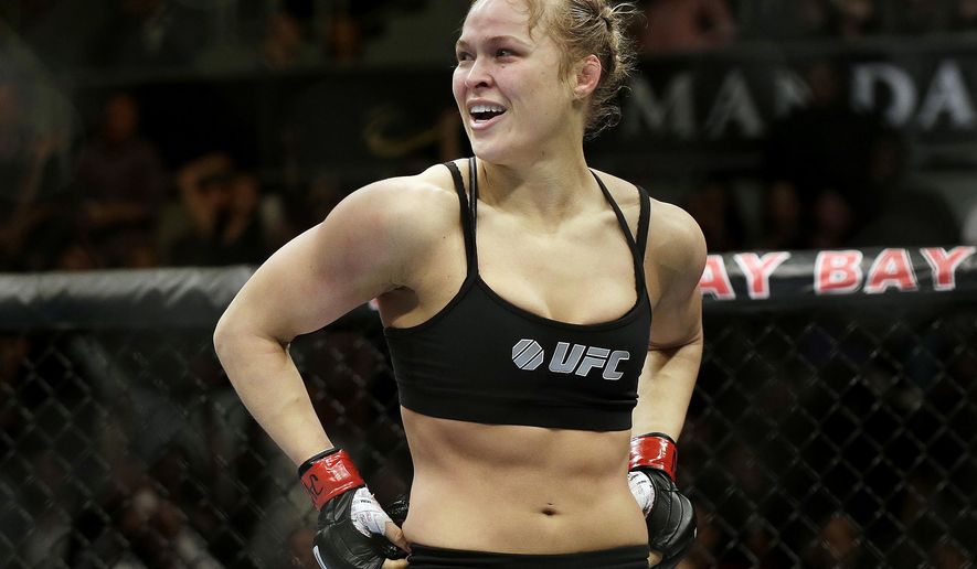 FILE - In this Feb. 22, 2014, file photo, Ronda Rousey looks around after defeating Sara McMann in a UFC 170 mixed martial arts women&#x27;s bantamweight title bout in Las Vegas. Rousey is returning to the UFC on Friday, Dec. 30, 2016, after a 13-month absence, taking on Amanda Nunes for the bantamweight title. The formerly dominant champion has declined to promote her comeback fight. (AP Photo/Isaac Brekken, File)