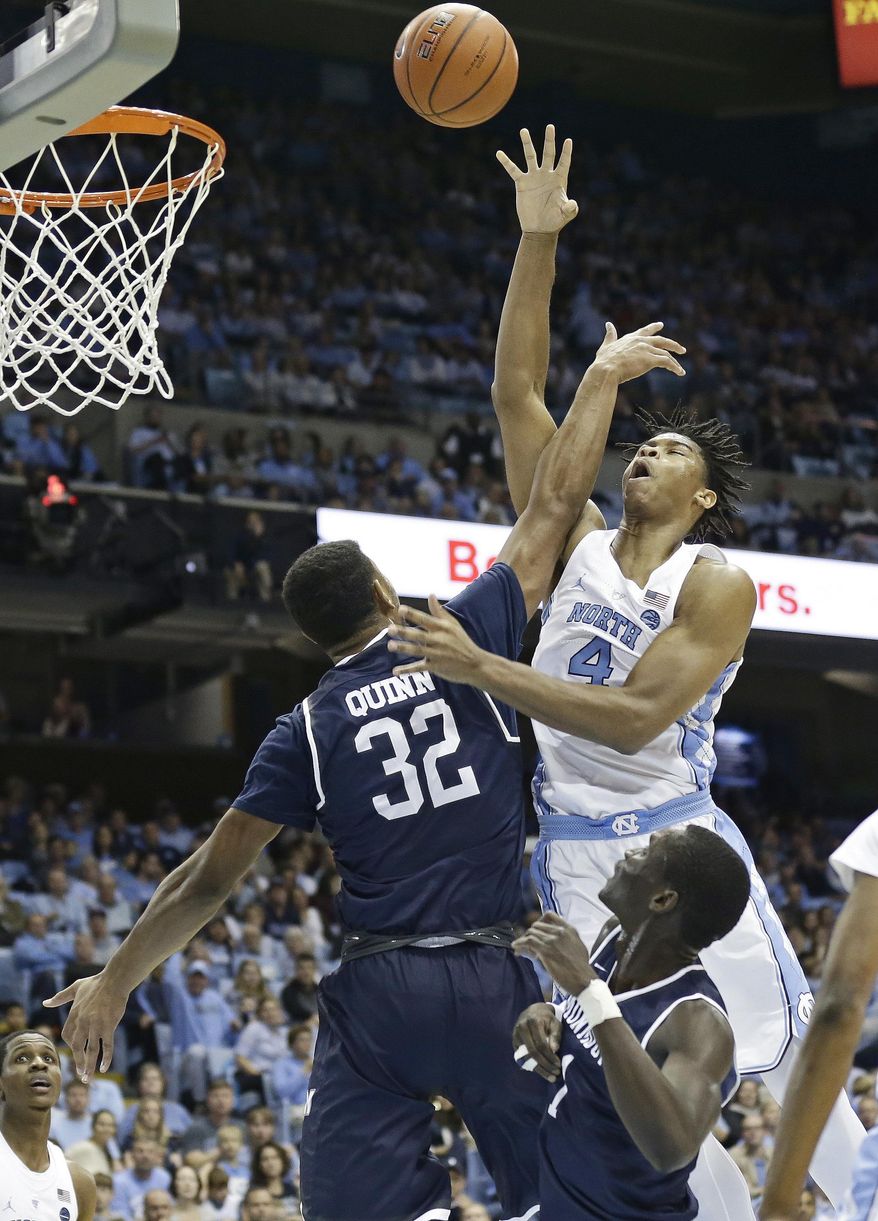 North Carolina's Isaiah Hicks (4) drives to the basket against Monmouth's Diago Quinn (32) during the first half of an NCAA college basketball game in Chapel Hill, N.C., Wednesday, Dec. 28, 2016. (AP Photo/Gerry Broome)