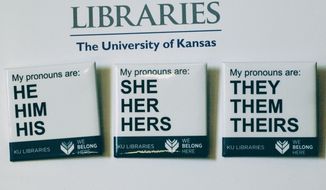 In this Tuesday, Dec. 27, 2016 photo, buttons advertising part of the University of Kansas Libraries&#39; &amp;quot;You Belong Here&amp;quot; campaign are displayed in Lawrence, Kansas. The campaign is aimed at making undergraduates, including those who are transgender, feel welcome. A number of University of Kansas Libraries employees now wear the buttons showing their preferred gender pronouns.  (Sara Shepherd /The Lawrence Journal-World via AP)
