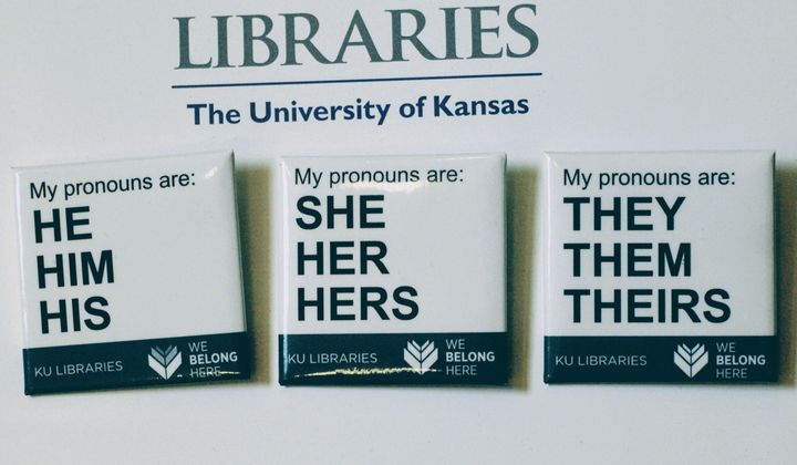 In this Tuesday, Dec. 27, 2016 photo, buttons advertising part of the University of Kansas Libraries&#x27; &amp;quot;You Belong Here&amp;quot; campaign are displayed in Lawrence, Kansas. The campaign is aimed at making undergraduates, including those who are transgender, feel welcome. A number of University of Kansas Libraries employees now wear the buttons showing their preferred gender pronouns. (Sara Shepherd /The Lawrence Journal-World via AP) **FILE**