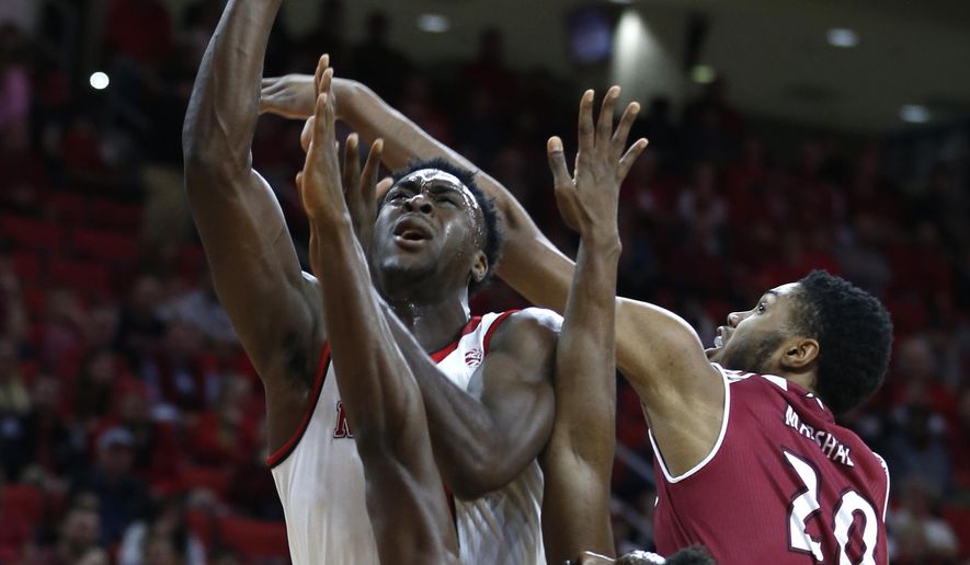 North Carolina State&#39;s Abdul-Malik Abu, left, shoots while Rider&#39;s Kahlil Thomas, bottom, and Tyere Marshall (20) defend during the first half of an NCAA college basketball game in Raleigh, N.C., Wednesday, Dec. 28, 2016. (Ethan Hyman/The News &amp;amp; Observer via AP)