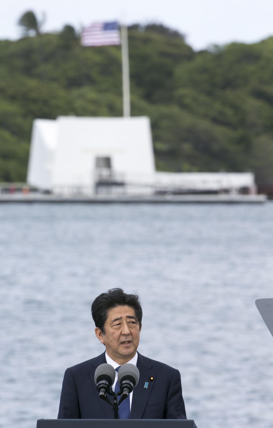 With the USS Arizona Memorial in the background, Japanese Prime Minister Shinzo Abe speaks at Joint Base Pearl Harbor Hickam, Tuesday, Dec. 27, 2016, in Hawaii. Abe and US President Barack Obama visited the USS Arizona Memorial Tuesday. (AP Photo/Marco Garcia)