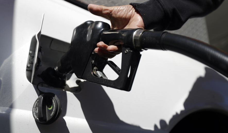 FILE - In this Wednesday, Oct. 26, 2016, file photo, an attendant at a Shell gas station pumps gas for a motorist in Hasbrouck Heights, N.J. Energy companies and banks led the rally on the S&P 500 in 2016. (AP Photo/Julio Cortez, File)
